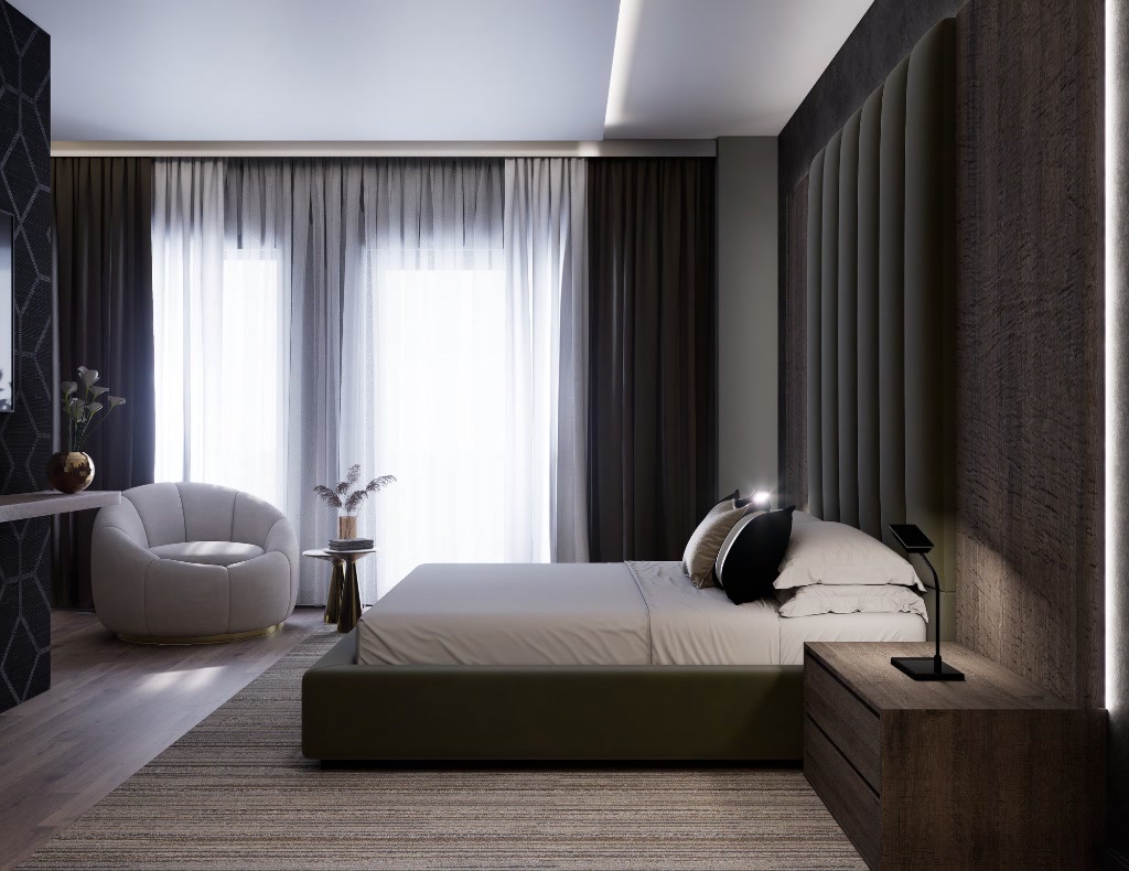 Master bedroom with upholstered headboard wall and curved lounge chair.